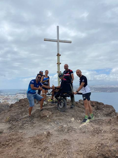 ¡Cumbre! Todo el equipo junto a la cruz, con la ciudad y el mar a los pies